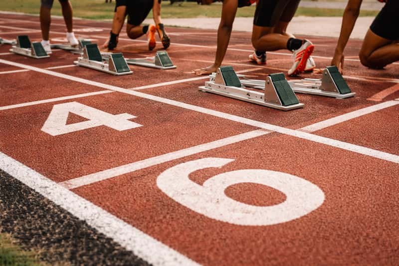 Starting blocks positioned on a running track with lane markings visible, ready for a sprinter to begin a 100-meter race